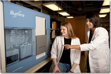 A strong proponent of student success, Preethi Gunaratne is pictured with one of the many students from her lab. Here, she points out the Illumina Genome Analyzer, a key piece of equipment used in her research, to graduate student Ashley Benham. (Photo by Thomas Campbell) 