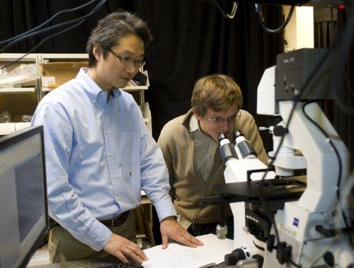 Jong Hyun Choi, an assistant professor of mechanical engineering at Purdue, and doctoral student Benjamin Baker use fluorescent imaging to view a carbon nanotube. Their research is aimed at creating a new type of solar cell designed to self-repair like natural photosynthetic systems. The approach might enable researchers to increase the service life and reduce costs for photoelectrochemical cells, which convert sunlight into electricity. (Purdue University photo/Mark Simons)