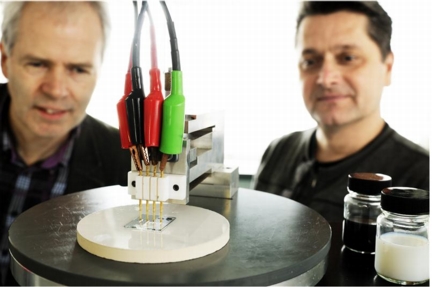 4-point conductivity measurement of the new transparent conducting film developed by prof. Cor Koning (left) and prof. Paul van der Schoot (right). The black pot contains a dispersion of carbon nanotubes in water, and the white pot contains the conducting latex. Photo: Bart van Overbeeke.