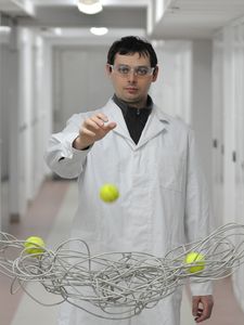 The viscosity does not depend only on the microscopic structure of a complex fluid (in the picture a cable coil represents polymer coils in a liquid), but also on the size of the probe used (represented by a tennis ball in the demonstration). The phenomenon is presented by Tomasz Kalwarczyk, a PhD student from the Institute of Physical Chemistry of the PAS. (Source: IPC PAS/Grzegorz Krzyżewski)
