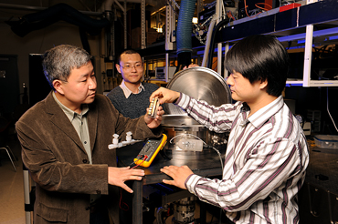 Xinwei Wang, Guoqing Liu and Xiaopeng Huang, left to right, show the instruments they used to study the thermal conductivity of spider silk.  Photo by Bob Elbert.