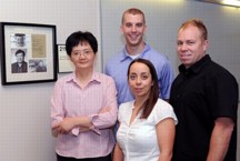 Members of Kan Wang's research team gather in a Hach Hall meeting area dedicated to the late Victor Lin of Iowa State University and the Ames Laboratory. From left to right are Wang, a professor of agronomy; Justin Valenstein, a doctoral student in chemistry; Susana Martin-Ortigosa, a post-doctoral research associate in Wang's lab; and Brian Trewyn, an associate scientist in chemistry.  Photo by Bob Elbert.