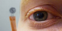 Figure 1: The contact lens display with the dollar sign held next to a human eye