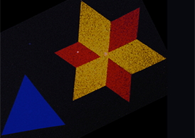 A false-color electron microscopy image showing the star-shaped crystals in monolayers of two-dimensional semiconducting molybdenum disulfide. The red, yellow, and blue colors represent two dominant crystal orientations that are stitched together by a line of atomic defects. Image courtesy of Pinshane Y. Huang and David A. Muller