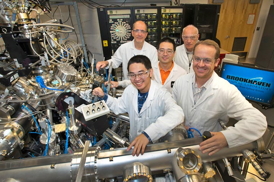 Click on the image to download a high-resolution version. Collaborating scientists stand with the atomic layer-by-layer molecular beam epitaxy system (ALL-MBE) used to synthesize the more than 800 differently doped samples used in the new study. Front row, from left: Yujie Sun, Anthony Bollinger; center: Jie Wu; back, from left: Ivan Bozovic, Zoran Radovic (visiting scientist from Serbia's Belgrade University).