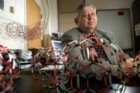 Harry Dorn, a professor at the Virginia Tech Carilion Research Institute, poses with models of "buckyballs." His research supports the theory that a soccer ball-shaped nanoparticle commonly called a buckyball is the result of a breakdown of larger structures rather than being built atom-by-atom from the ground up.

Credit: Virginia Tech