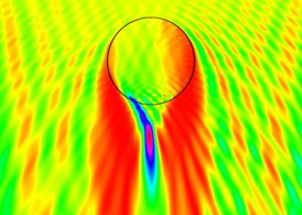 Nanoengineers have invented a spherical nanorobot made of silica that focuses light like a near-field lens to write surface patterns for nanoscale devices. In this image, the red and purple areas indicate where the light is being magnified to produce a trench pattern on light-sensitive material. The researchers published their novel nanomotor lithography method recently in the journal Nature Communications. Image credit: Laboratory for Nanobioelectronics, UC San Diego Jacobs School of Engineering.