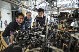 University of Chicago scientists can create an exotic, particle-like excitation called a roton in superfluids with the tabletop apparatus pictured here. Posing from left are graduate students Li-Chung Ha and Logan Clark, and physics Professor Cheng Chin.
CREDIT: Rob Kozloff, University of Chicago