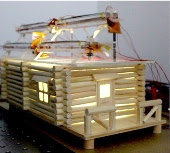 Hybrid solar and wind harvesting cells on the top of this model house collect enough energy to light it up inside. 
Credit: American Chemical Society