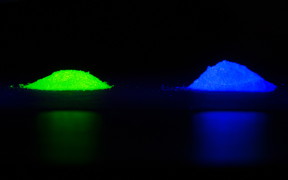Under UV light, the phosphor emits either green-yellow or blue light depending on the chemical activator mixed in. Photos by David Baillot/UC San Diego Jacobs School of Engineering