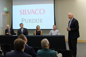 Purdue Research Foundation President Brian Edelman speaks at contract signing event with Silvaco Inc. officials Thursday (Aug. 23) at the Kurz Purdue Technology Center. Silvaco will license Purdue University intellectual property, sponsor research at Purdue and open an office in the Purdue Technology Center. Seated at the table, from left, are David Duerson, Silvaco CEO; Iliya Pesic, executive chairman of the Silvaco board of directors; Brooke Beier, vice president of the PRF Office of Technology and Commercialization; and Ken Sandel, senior director of Purdue sponsored program services. (Purdue Research Foundation Image/John Underwood)