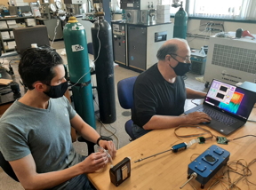 URI doctoral student Peter Ricci (left) and Professor Otto Gregory test the Digital Dog Nose sensors platform in Gregory's Thin Film Sensors Laboratory at URI. The blue devices on the table represent the two latest versions of the Digital Dog Nose.

CREDIT
Photo by Mike Platek